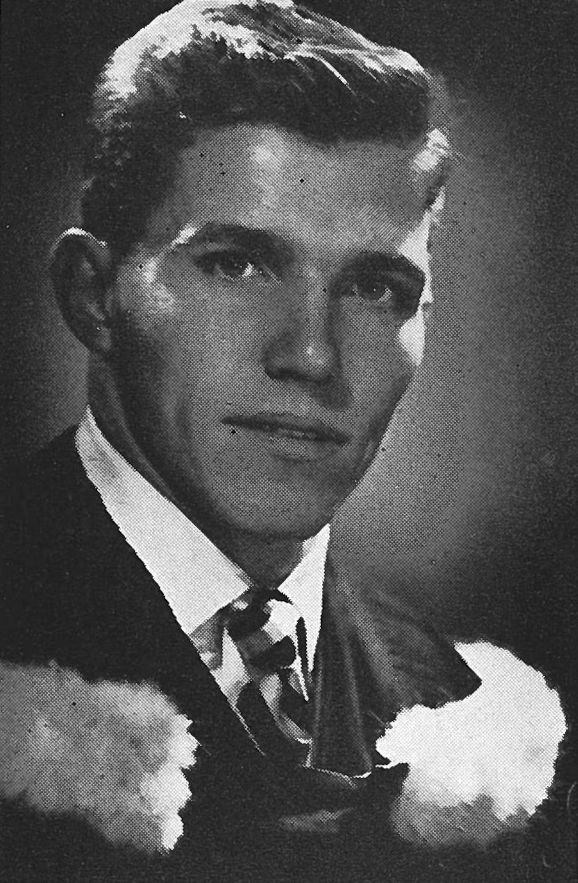 A black and white headshot of a young man in a suit and tie.