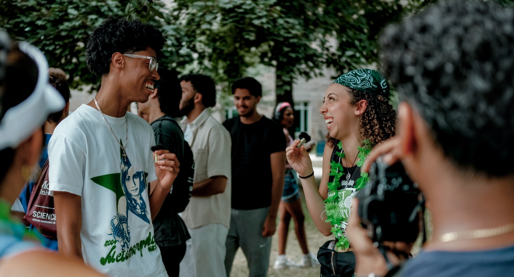 Two students smile widely at each other.