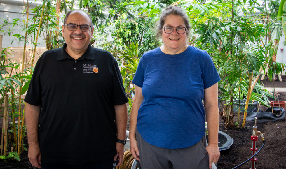 Project manager Sam Sargeos and professor Susan Dudley standing and smiling in the new greenhouse