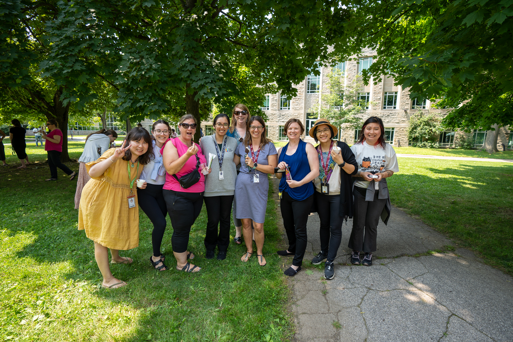 Saher Fazilat stands in the middle of a group of smiling people at the ice cream social