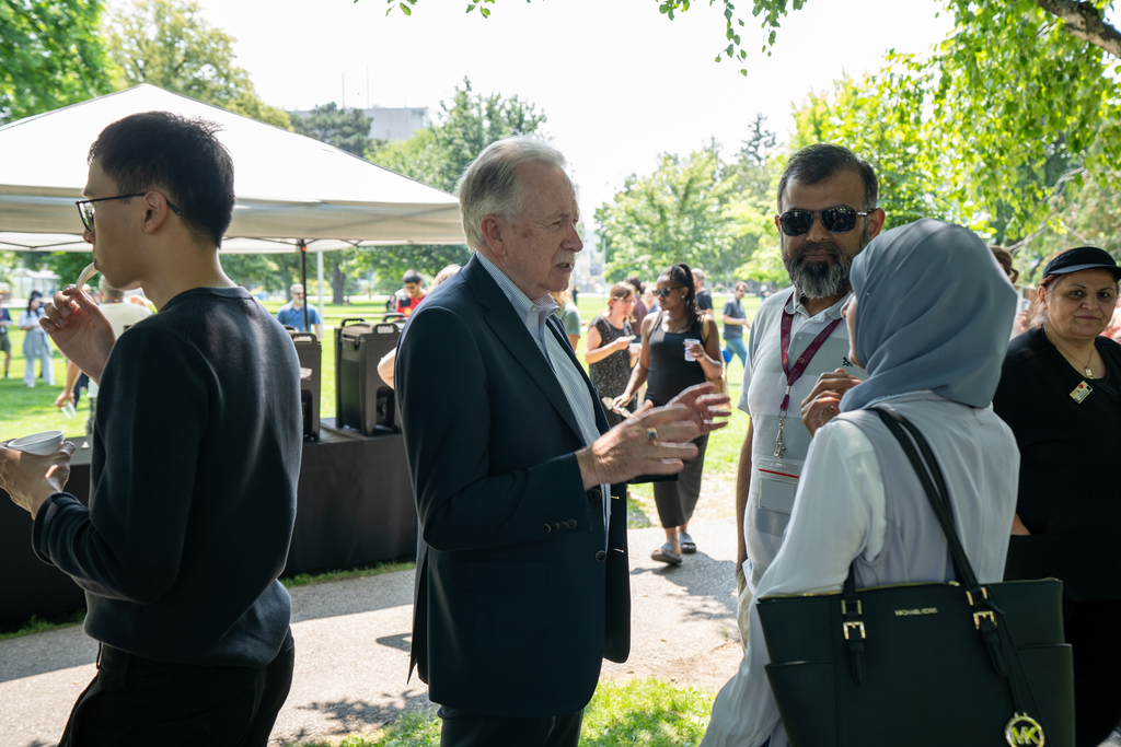 FHS dean Paul O'Byrne chats with staff and faculty members in a shady spot on BSB field