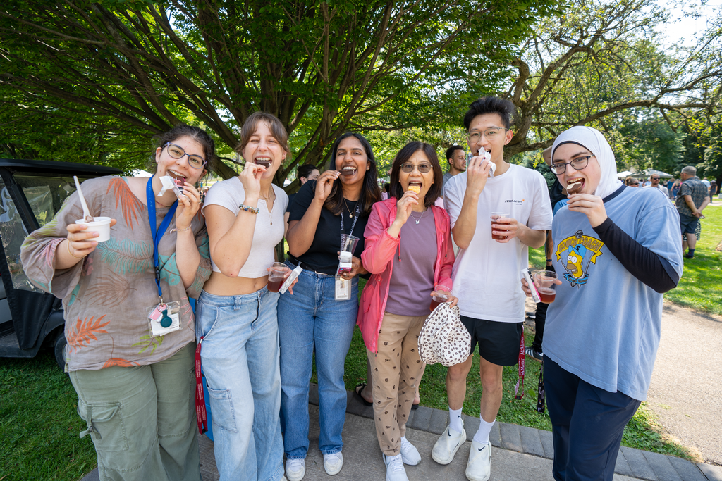 A smiling group of staff and students eating ice cream on BSB field.