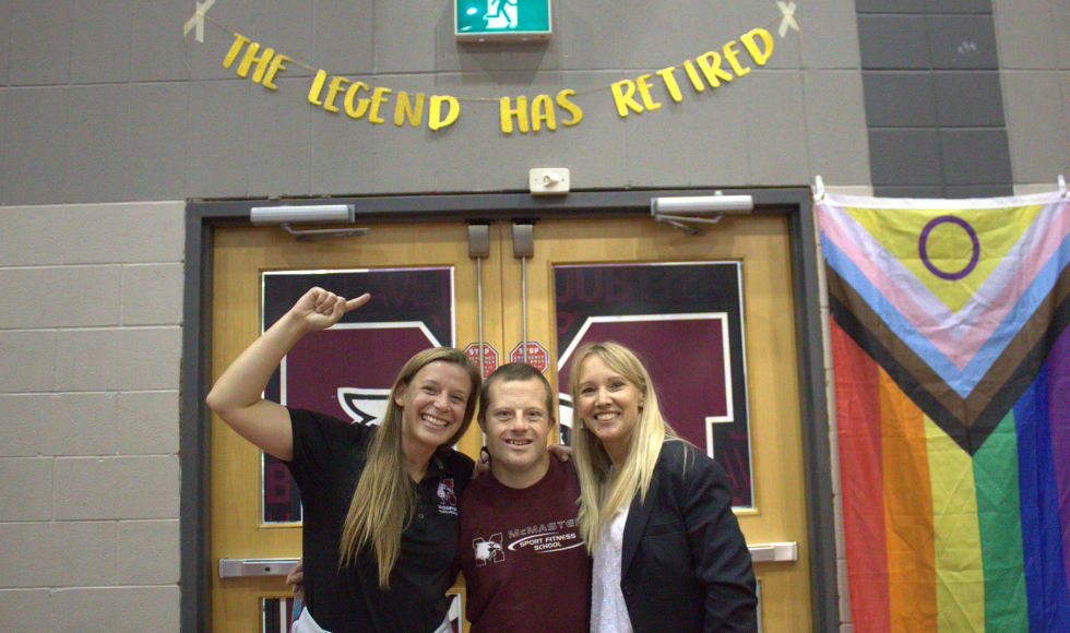 Mark Haggarty and two other people posing under a banner that reads, 'The legend has retired.' 