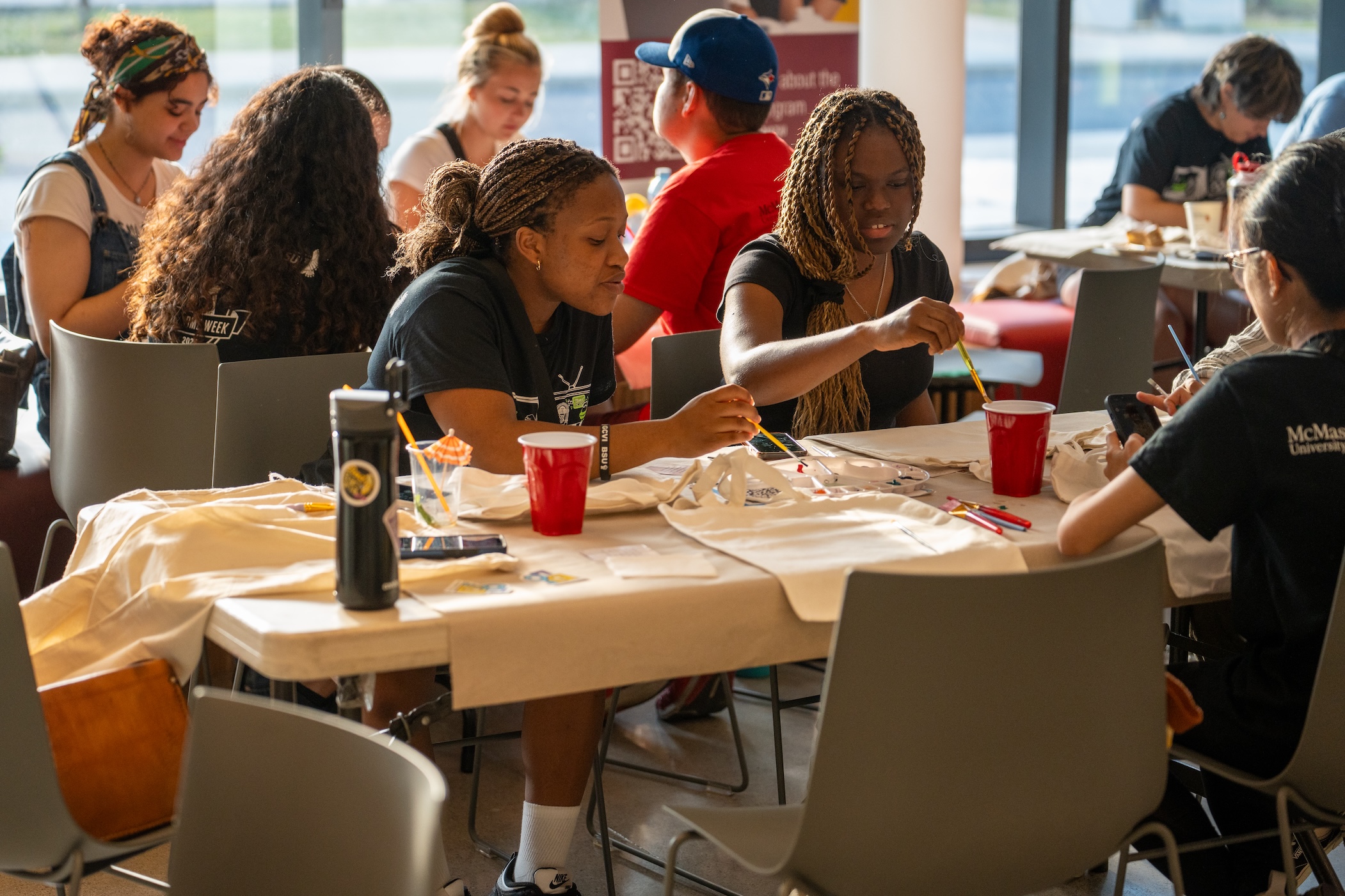 Students paint T shirts in the MSU hub space.