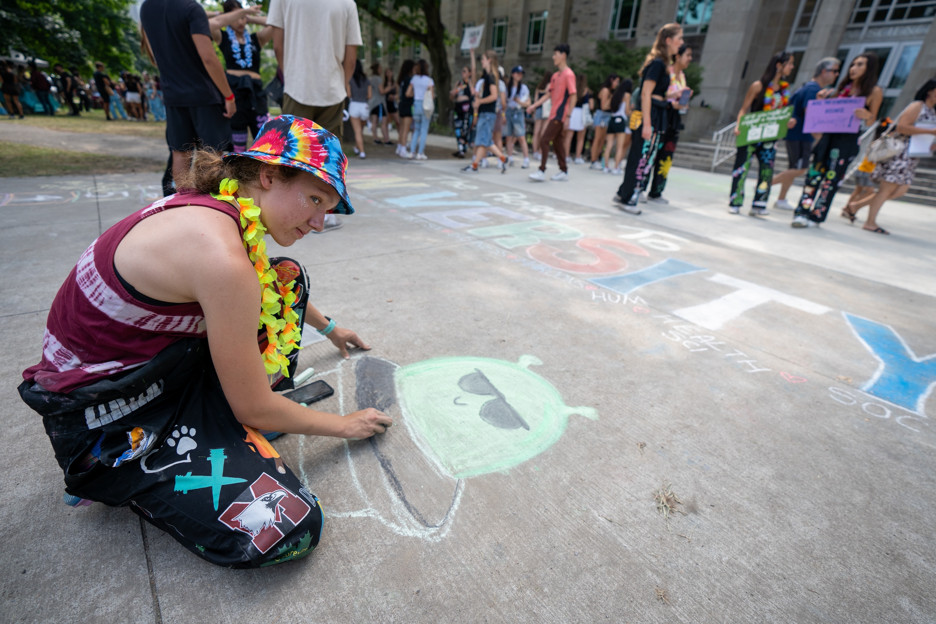 A WW rep draws with chalk outside Burke Science Building