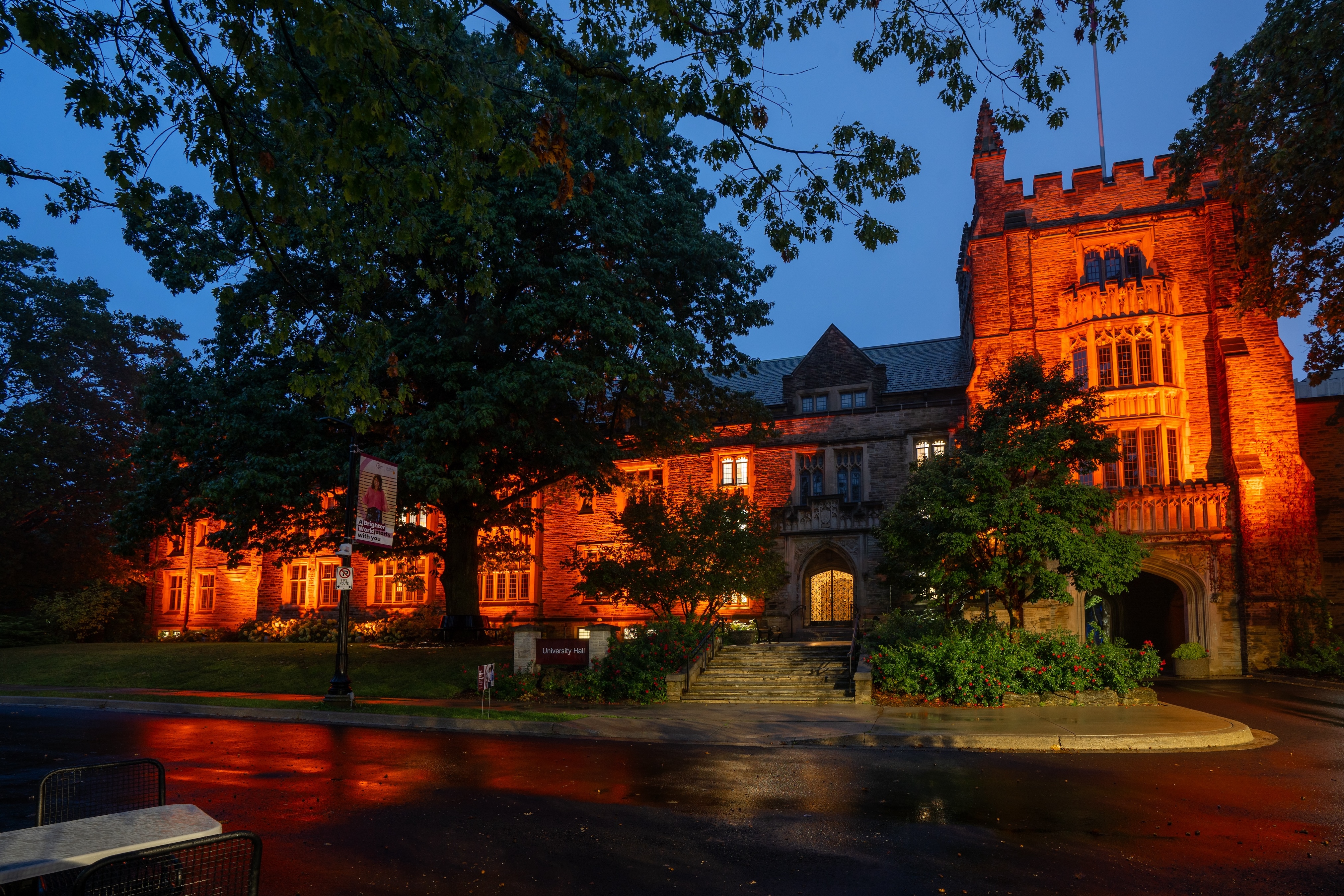 A nighttime shot of University Hall lit up with an orange light.