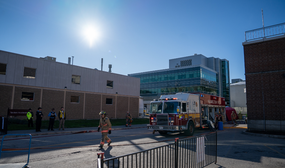 A firetruck on McMaster's campus. There are some first responders standing near the truck.