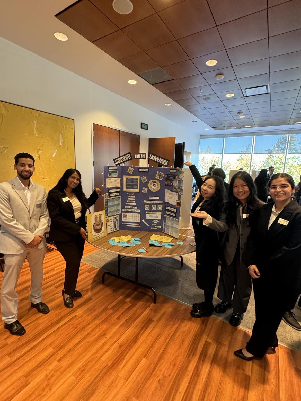 Smiling students stand at a poster presentation during GRIT WEEK