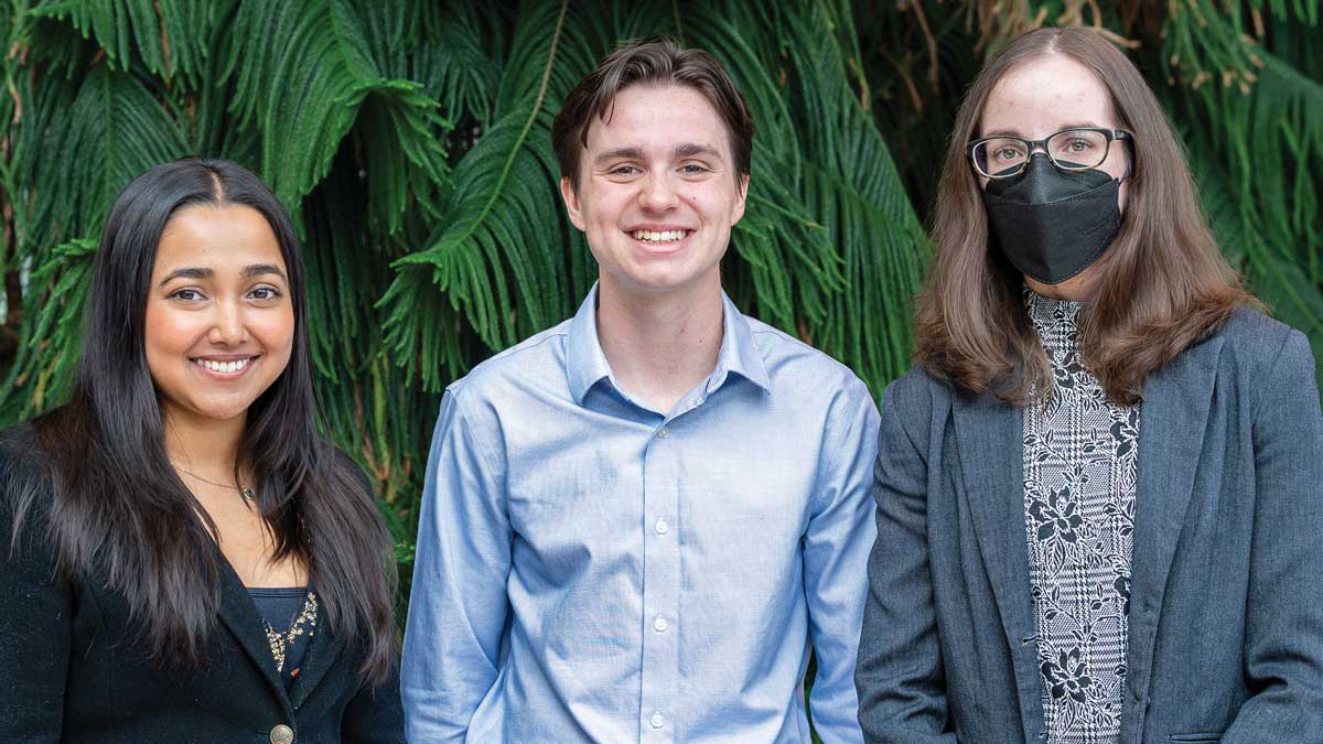 Three people standing in front of a tree looking directly at the camera 