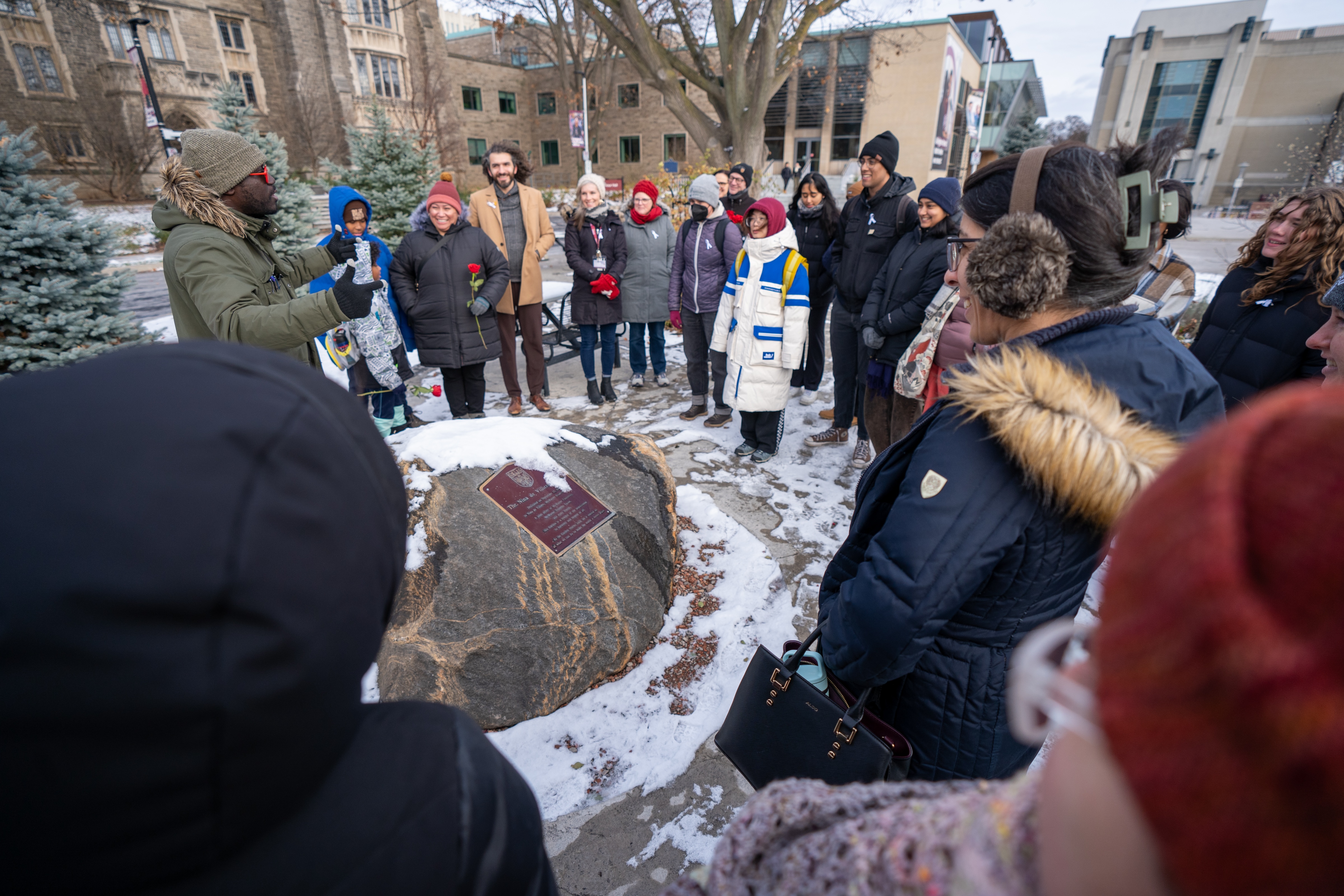 The memorial walk participants gather around a memorial stone in the heart of campus to pay tribute to a student. 