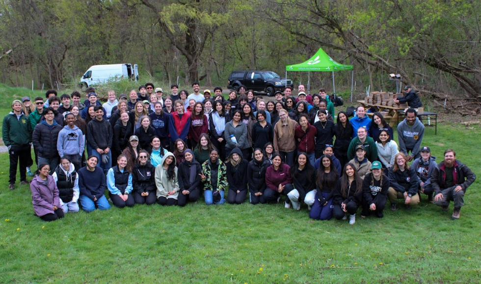 A group photo of approximately 40 people, standing on a lawn.