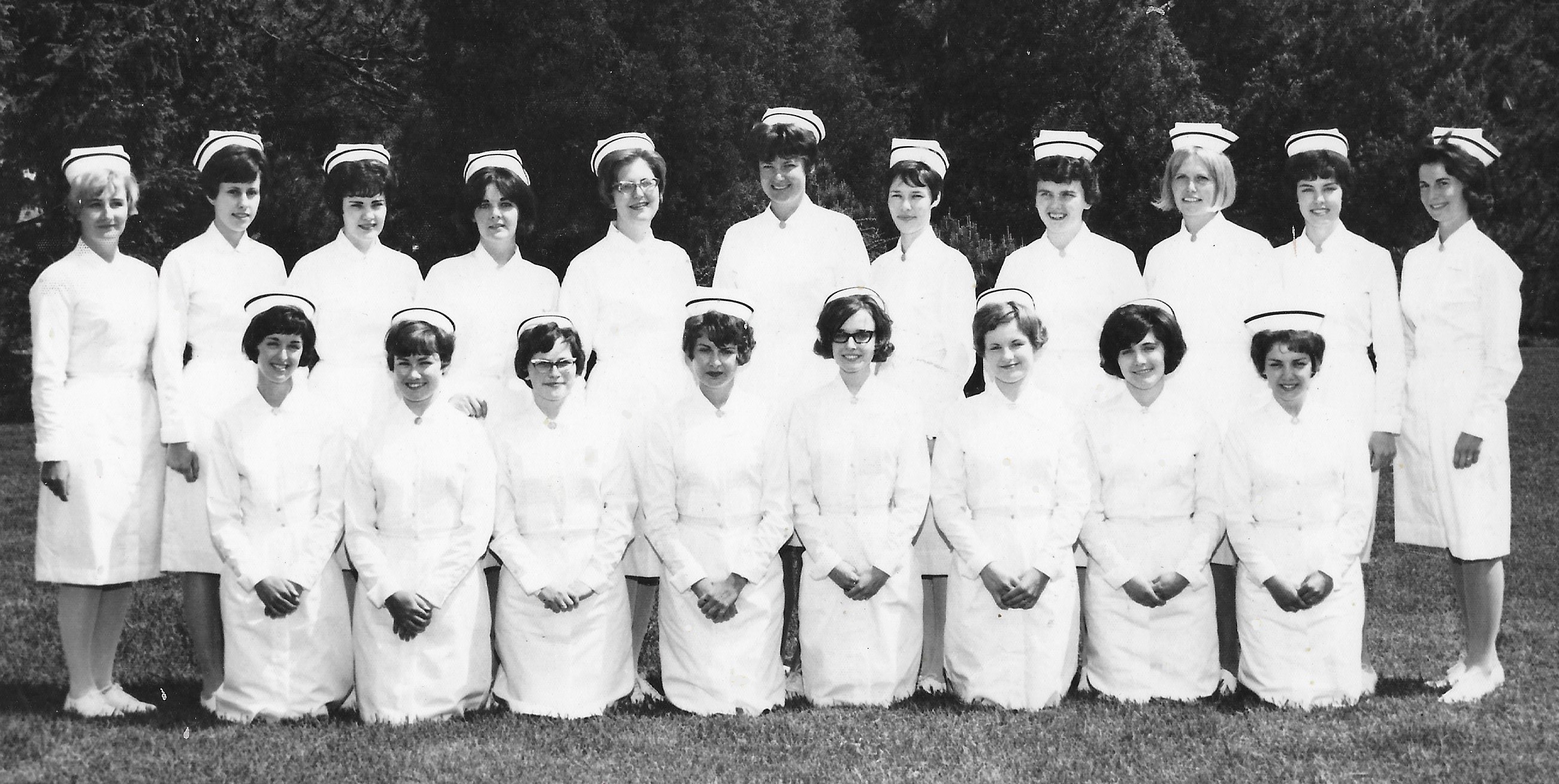 A black and white group photo of two rows of women in nurse's uniforms.