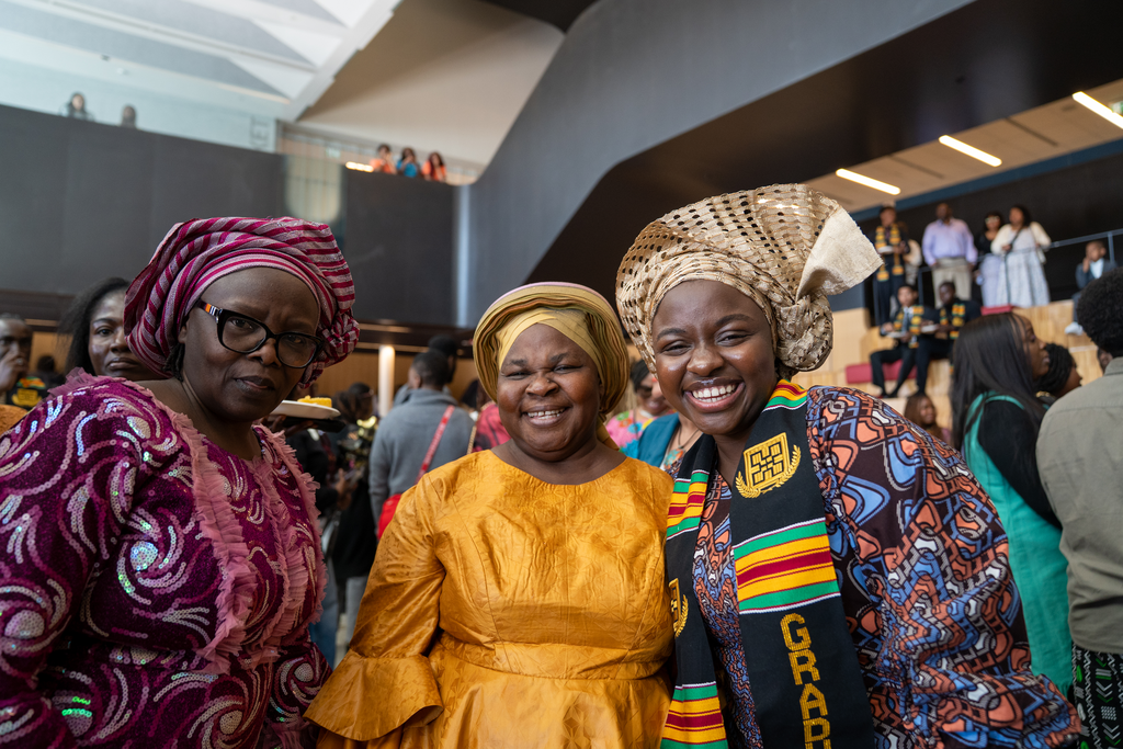 Three women pose together. 