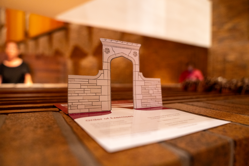 A printed itinerary with a pop-up an archway. 