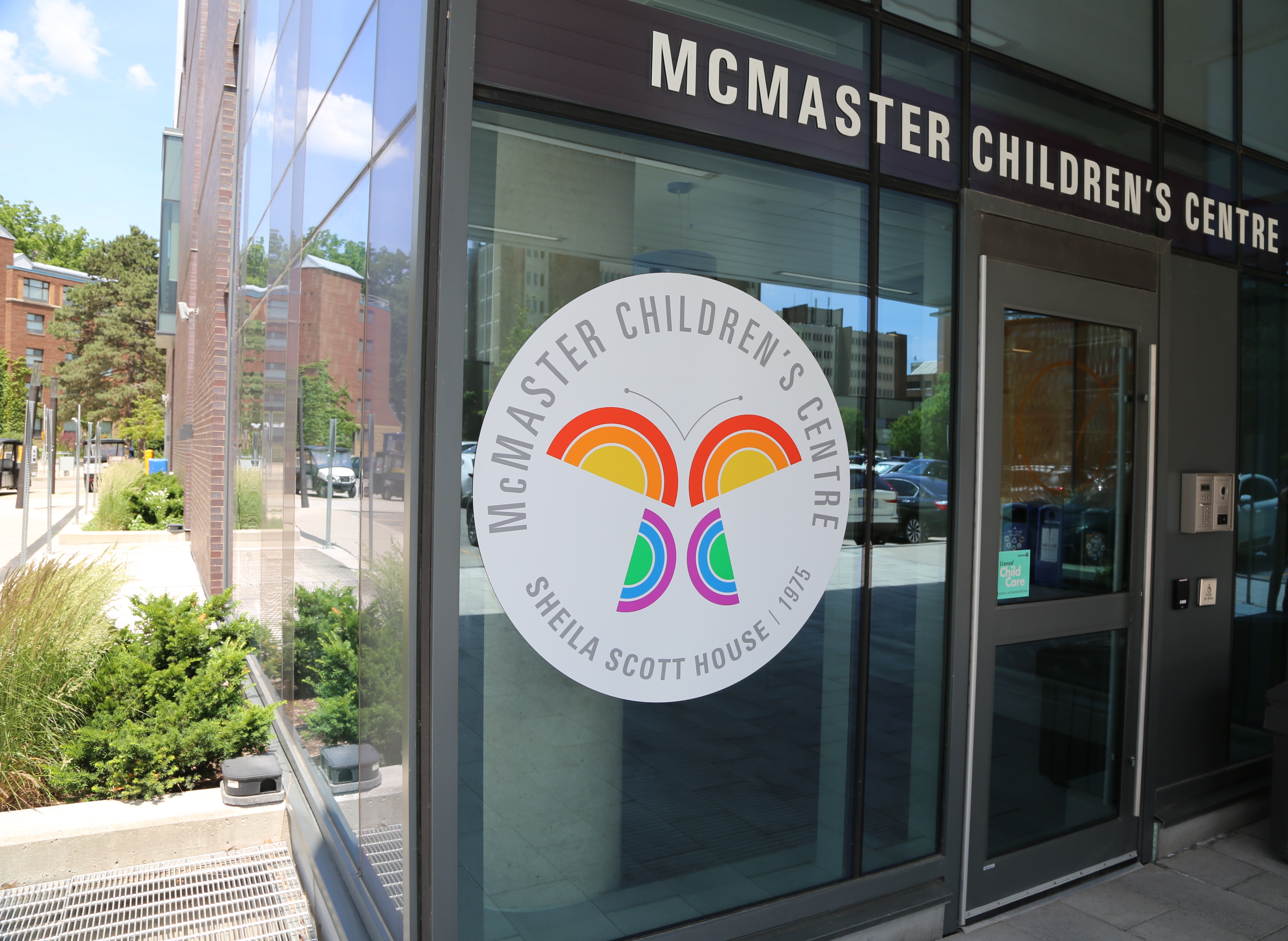 The front of a glass building, with a sign reading 'McMaster Children's Centre.'