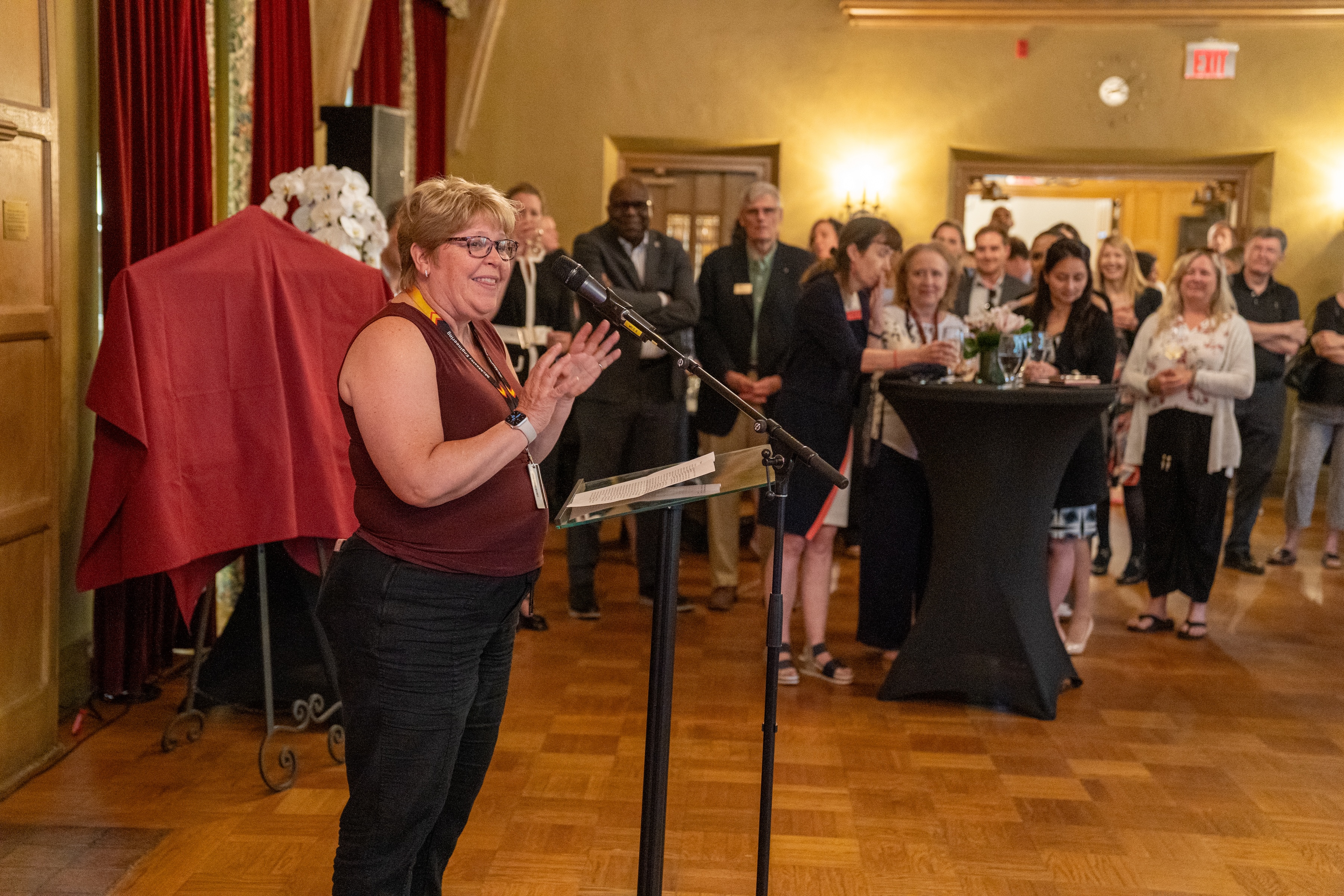 Heather Sheardown speaks into a mic during a gathering in Alumni Memorial Hall