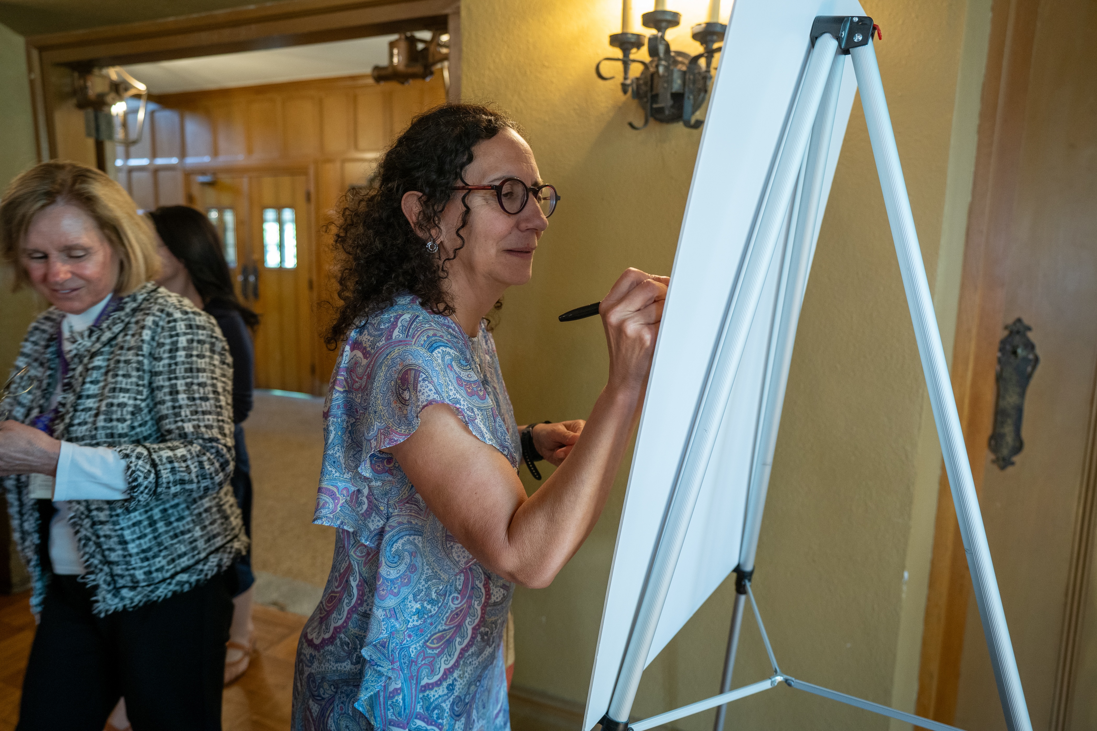 Dina Brooks signs a posterboard during a gathering in Alumni Memorial Hall