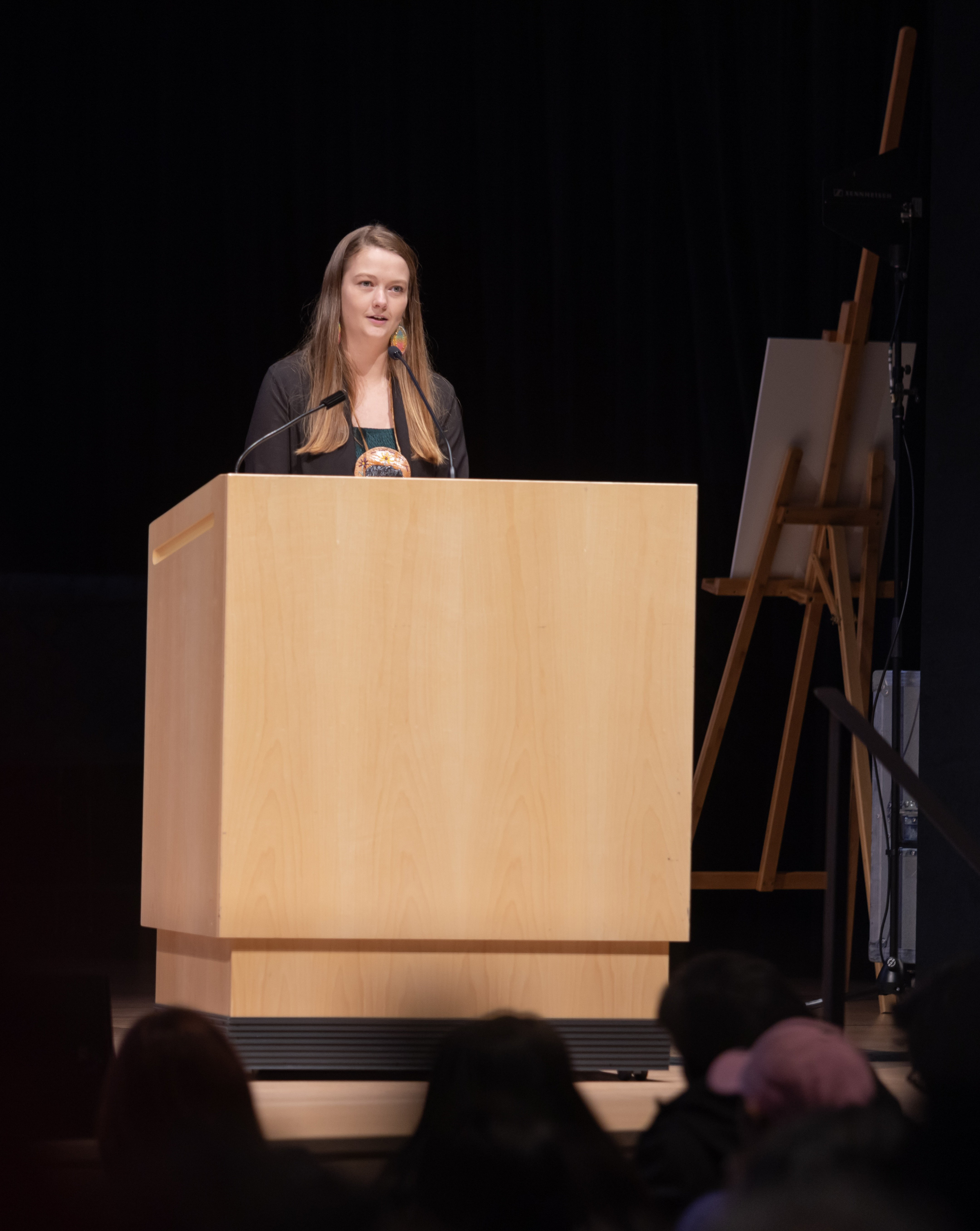 A woman stands at a large podium.