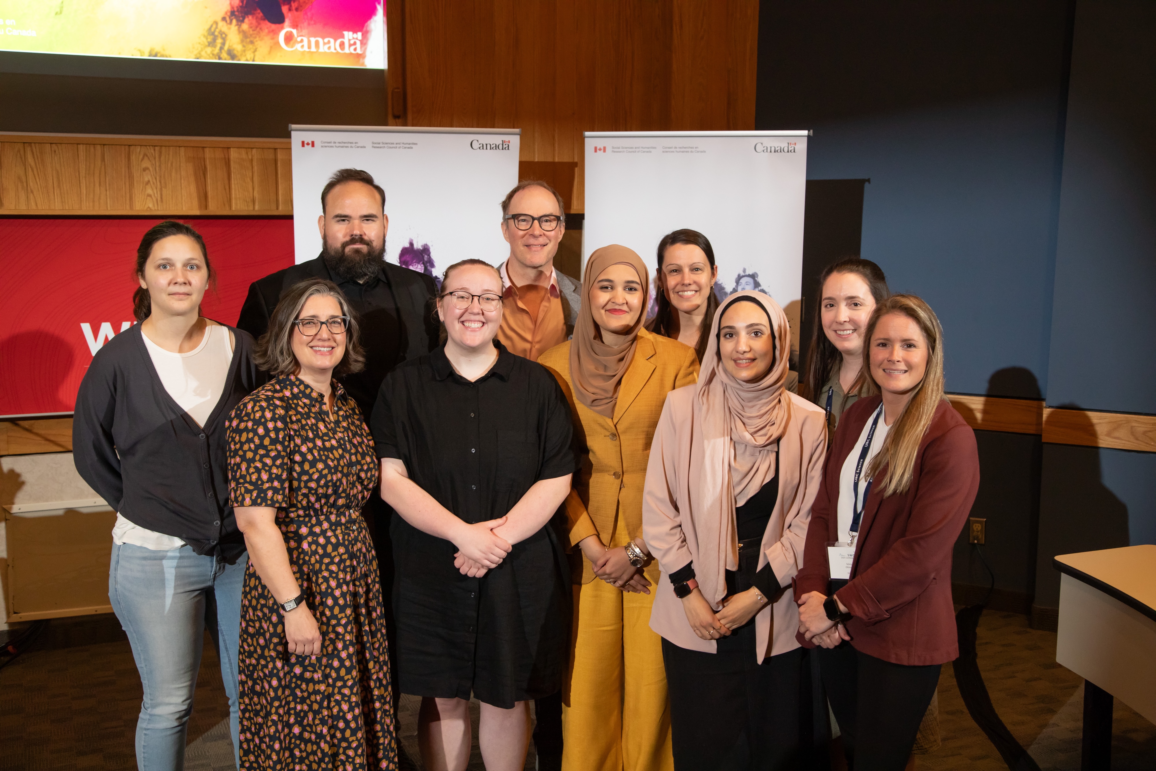 A group shot of ten people, in professional clothing.
