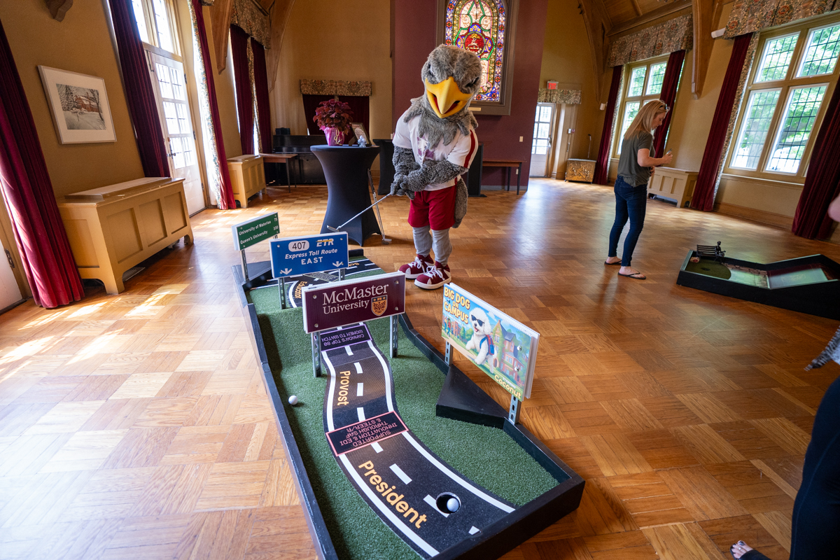 Mac the Marauder holds a putter at the mini golf course set up in Alumni Memorial Hall.