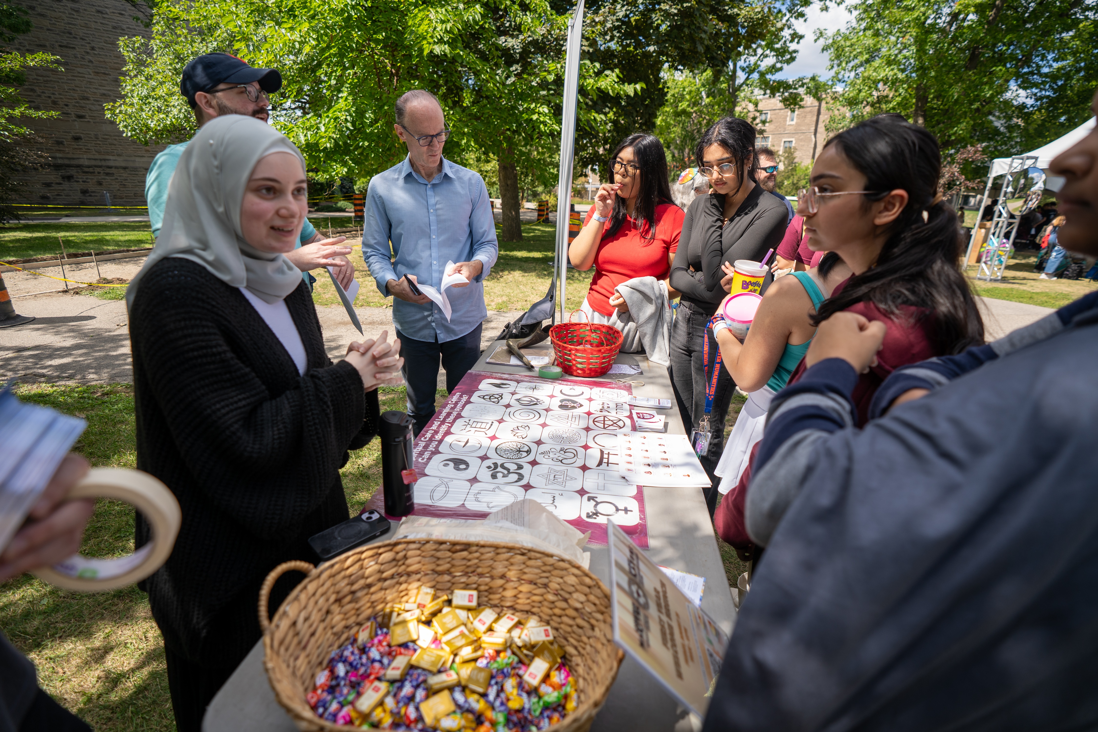 A group of students chat with organizers at a table during Community Connections at Welcome Week 2025