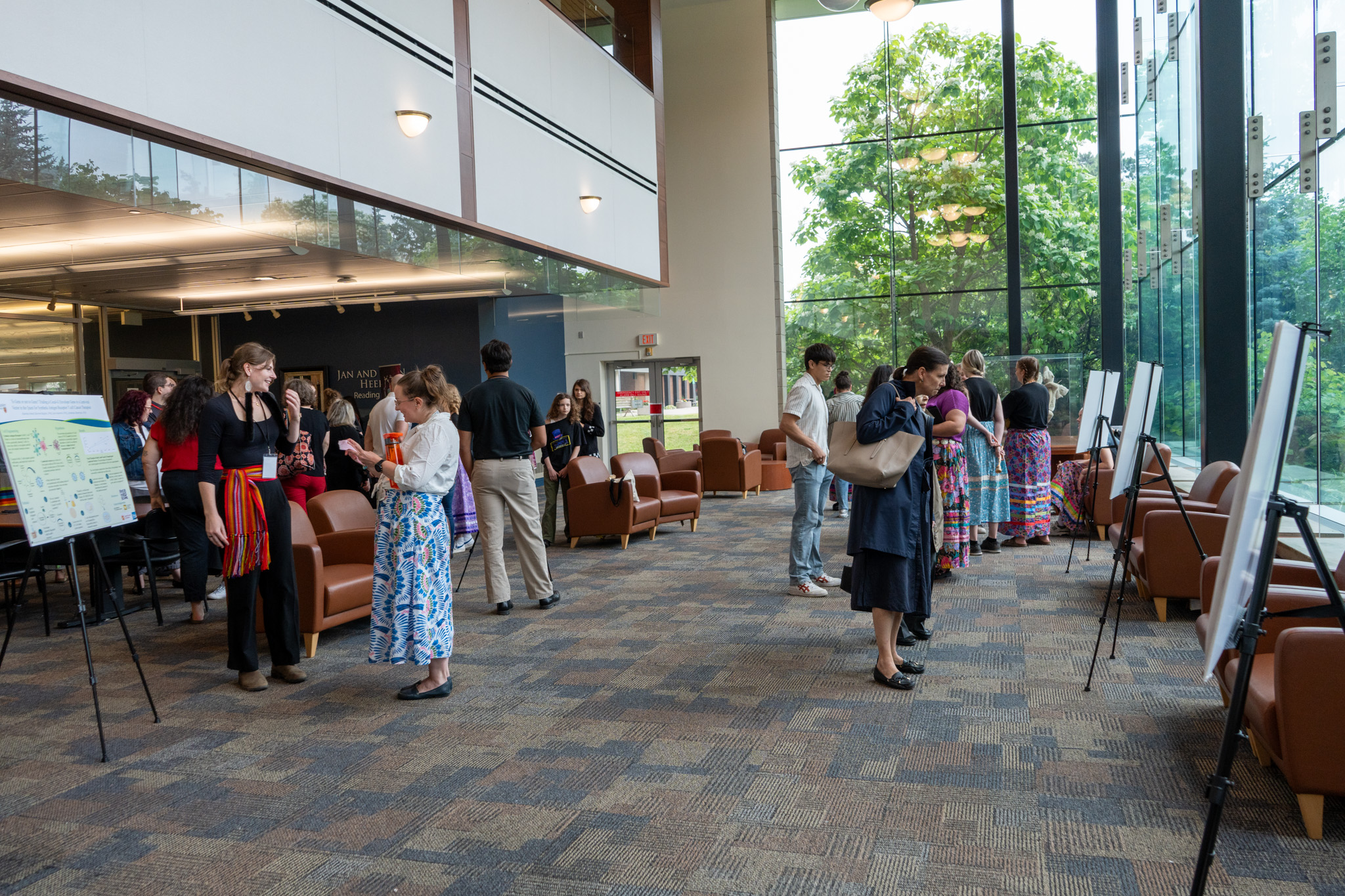 In an atrium, people mill around, looking at large posters.