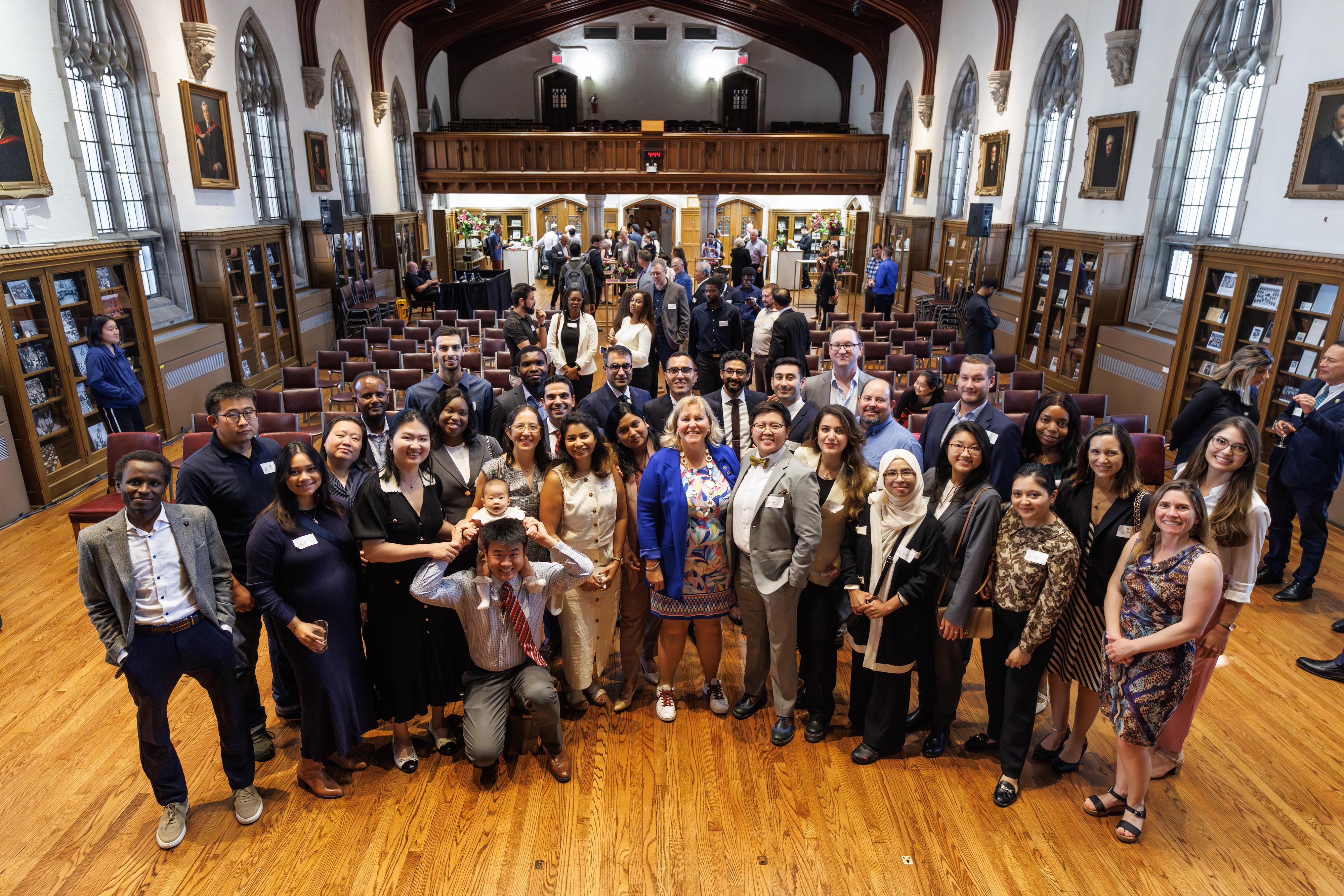 About 30 smiling people pose for a group photo after the Pavement to Presidency event in Convocation Hall.