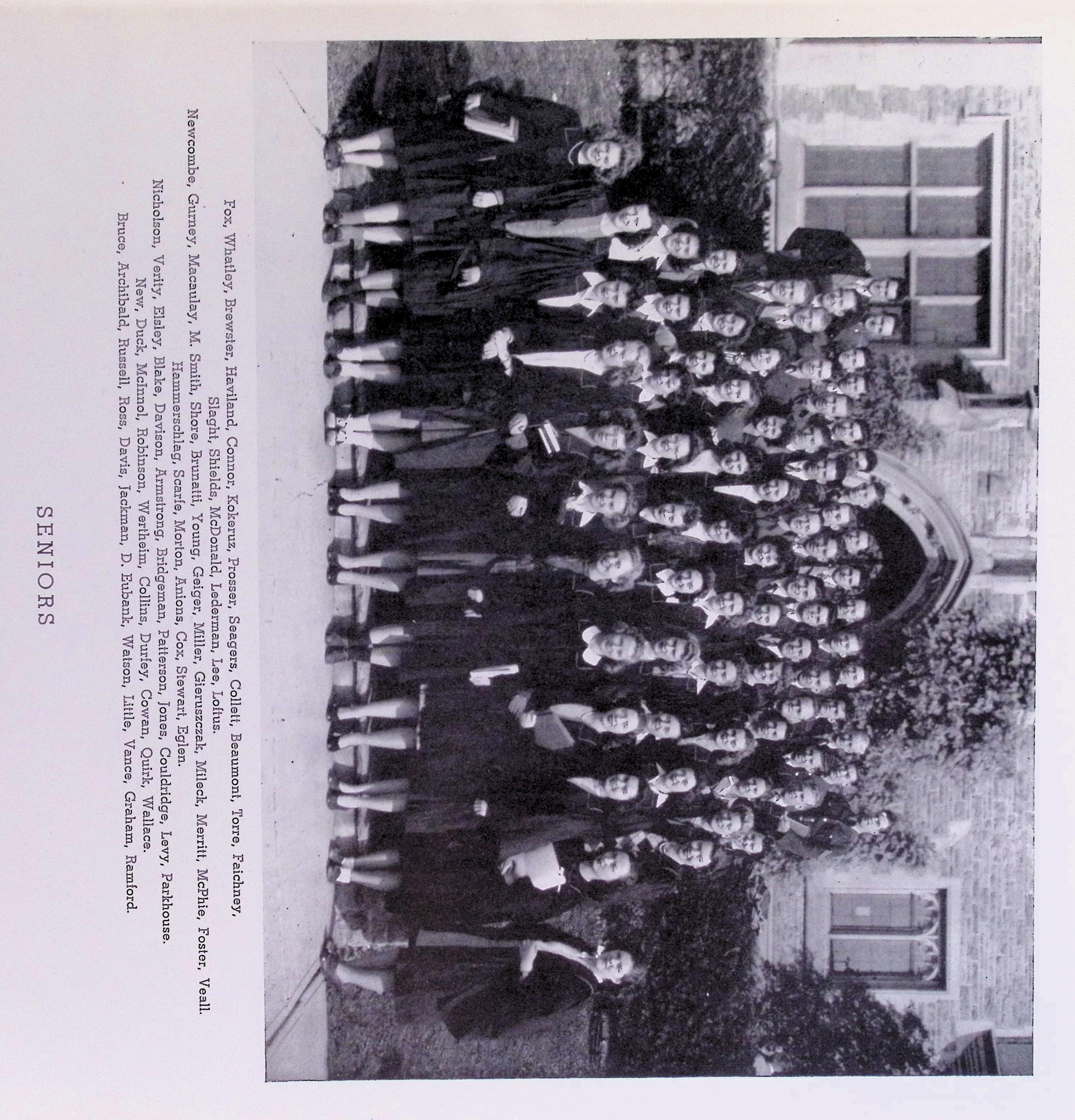 A group shot of many people standing on the steps of a building, in academic dress.