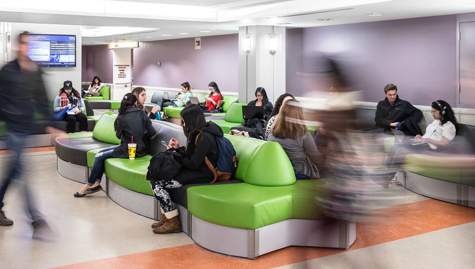 Image of students sitting/walking in the lobby of Mills Library.
