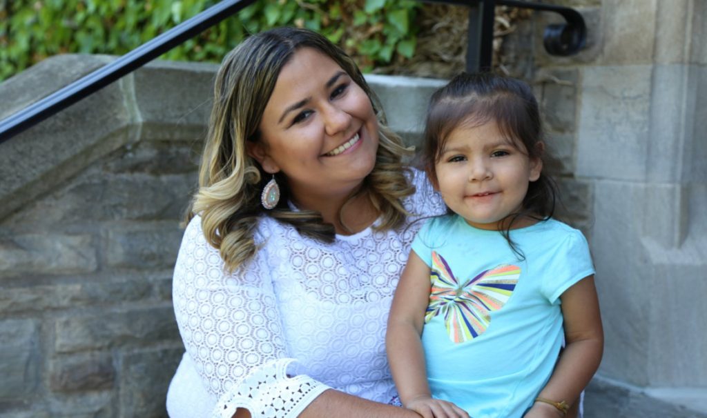 Katelyn Knott and her three-year-old daughter, Iris, share a smile on McMaster University campus ahead of Katelyn's graduation with an Honours degree in anthropology and Indigenous Studies.
