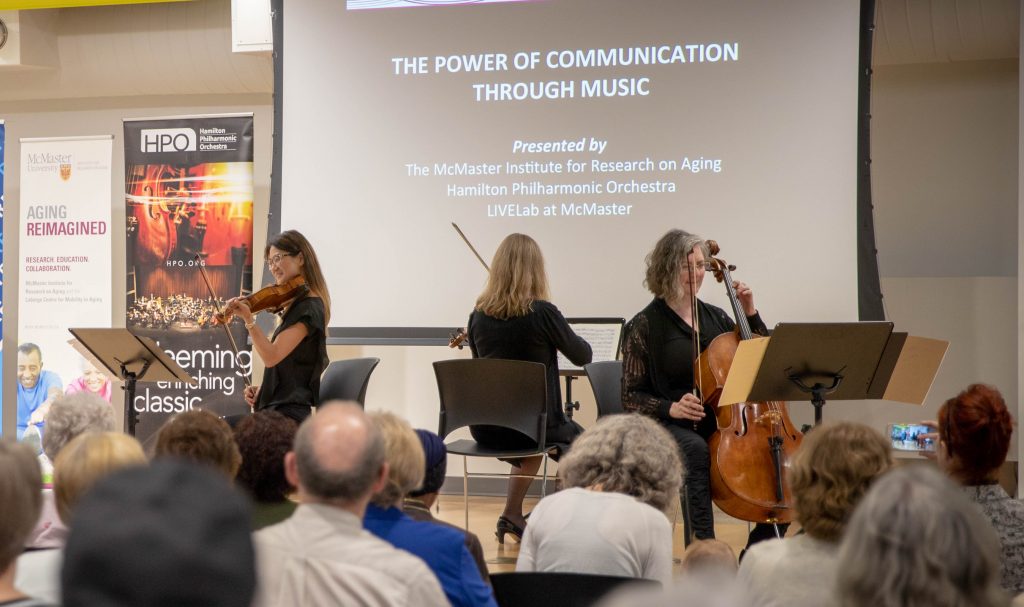 Hamilton Philharmonic Orchestra violinist Cecilia Chang, viola player Elspeth Thomson and cellist Laura Jones play chamber music with their backs turned at an event illustrating the power of communication through music at the Hamilton Public Library. Photo by Anna Verdillo