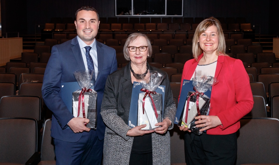 Dave Mammoliti, Sonia Hawrylyshyn and Erica Balch stand together in Wilson Hall, holding their awards