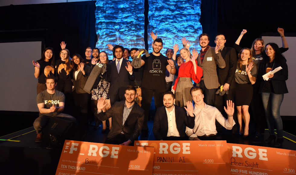 A group of students from the Forge Student Pitch Competition stand on a stage