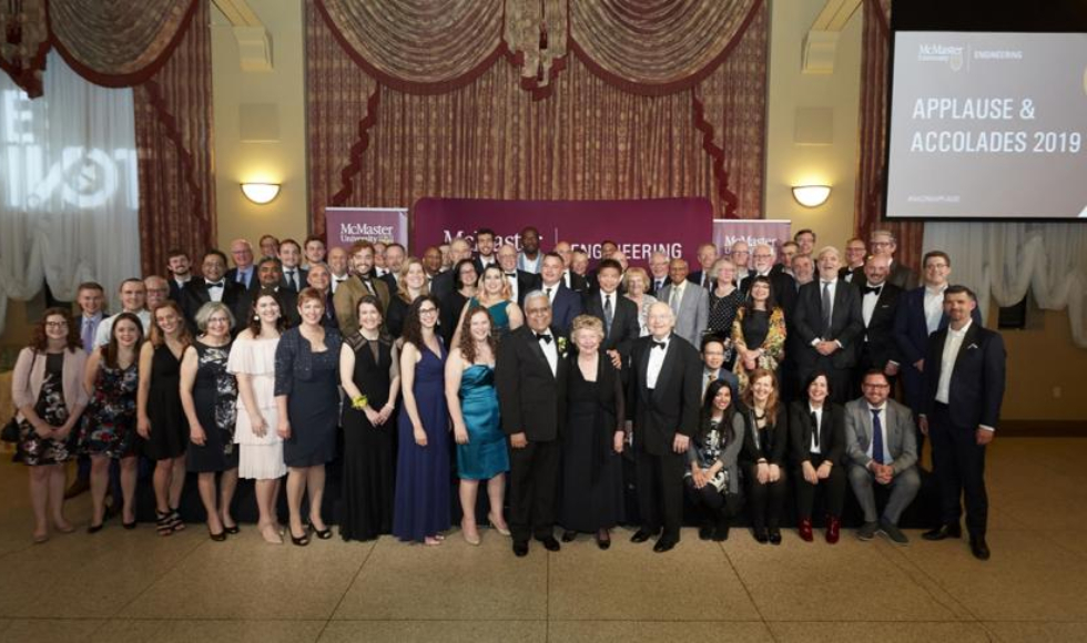 Large group photo of people in front of a sign that says Applause and Accolades 2019