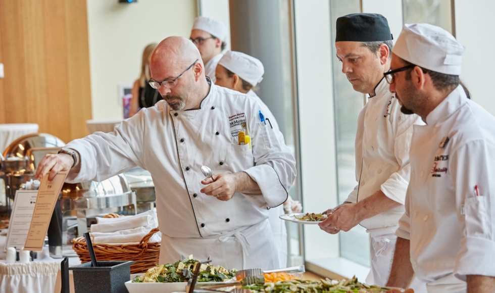 Several servers and chefs staff a catering event