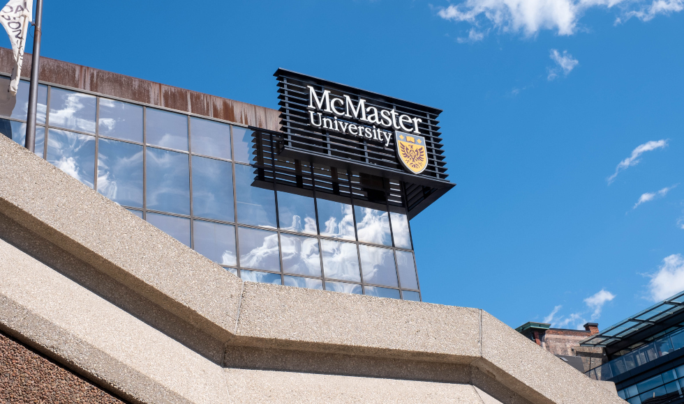 The McMaster sign is shown on a glass building against a blue sky
