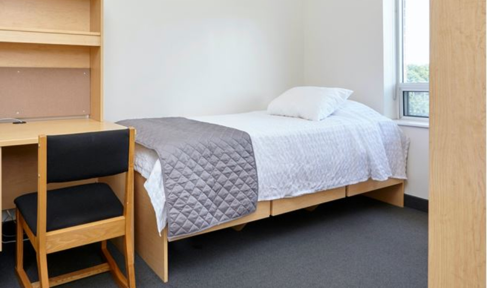 A residence room with a single bed and bookcase