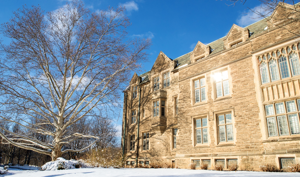 A photo of UNiversity Hall in winter with a bright blue sky and sunshine