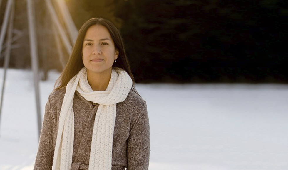 Nadine Caron standing outdoors against backdrop of a tree and snow.