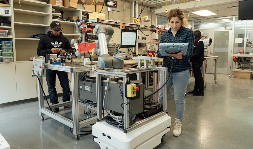 Students working on equipment and computers at the W Booth School.