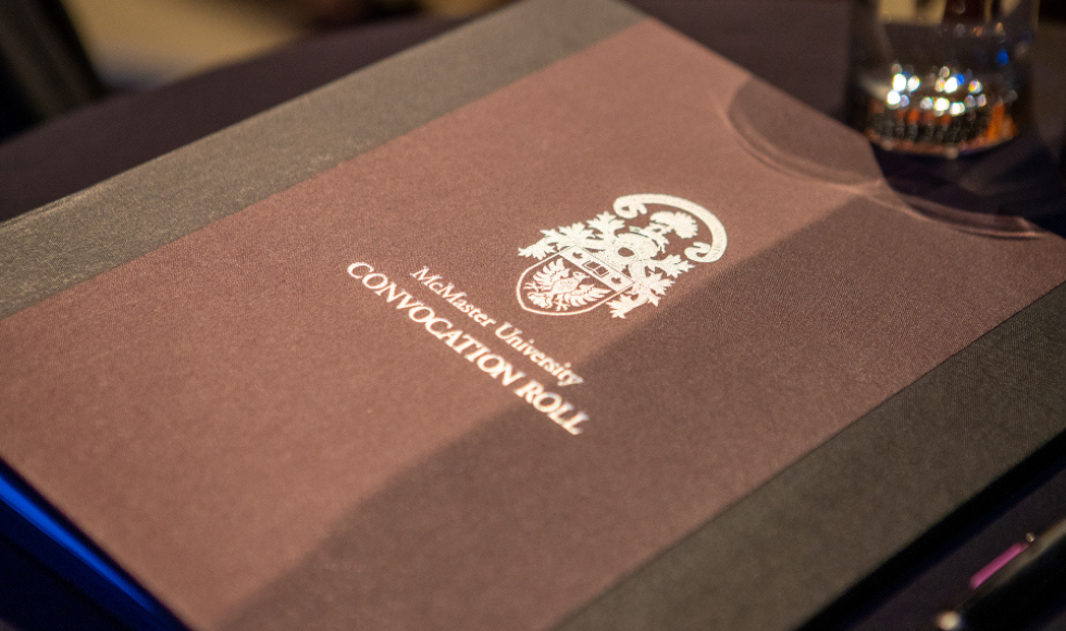 The front cover of a book that has the McMaster Coat of Arms on it and reads 'Convocation Roll'