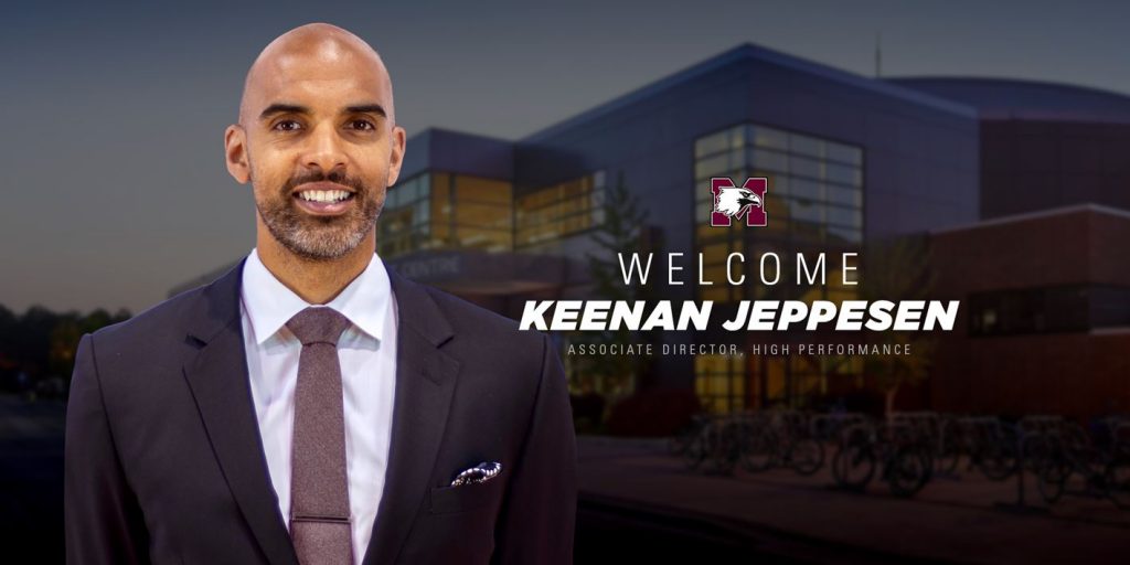 Man in a suit next to a graphic of McMaster athletics logo