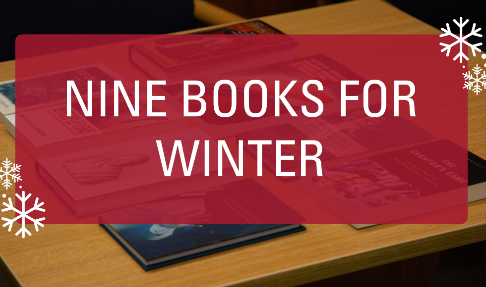 A picture of several books lying on a table. Over the image there is a graphic that reads ’nine books for winter.’ The text is in white and is on a red background. There are graphics of snowflakes in the corner of the image.