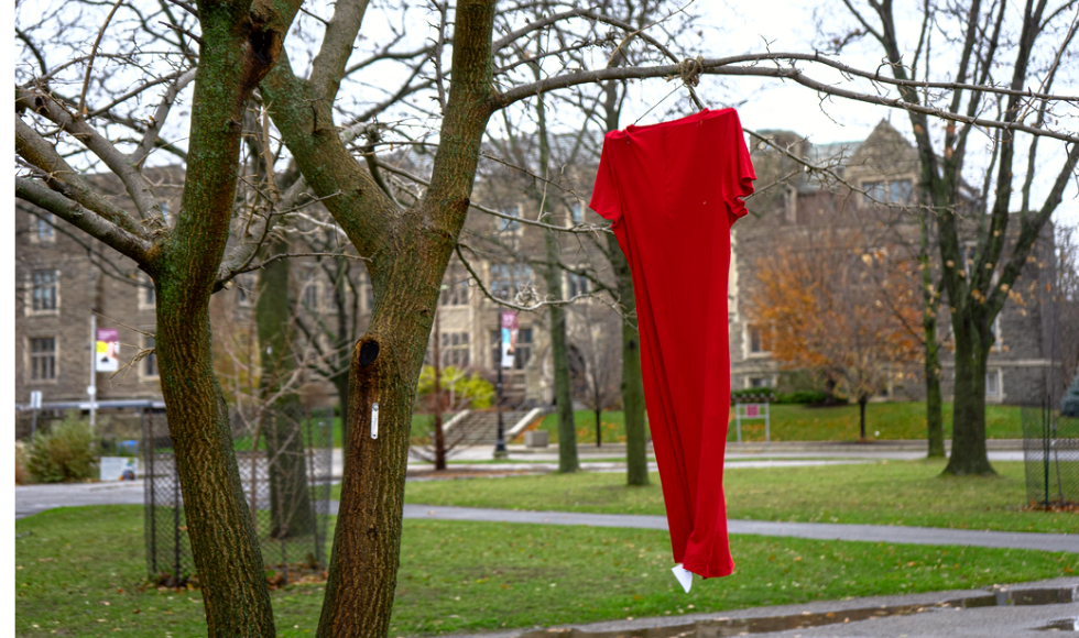 A red dress hanging from a tree on McMaster's campus.