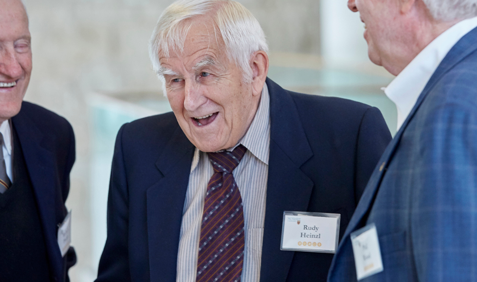 Rudy Heinzl, former dean of Student Affairs at McMaster at a networking event. Older man in his 80s, wearing a suit jacket and tie.