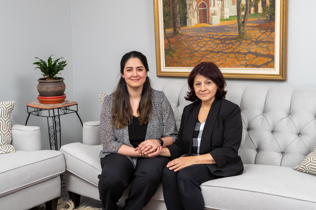 A photo of Hila Taraky and Marufa Shinwari sitting on a couch.