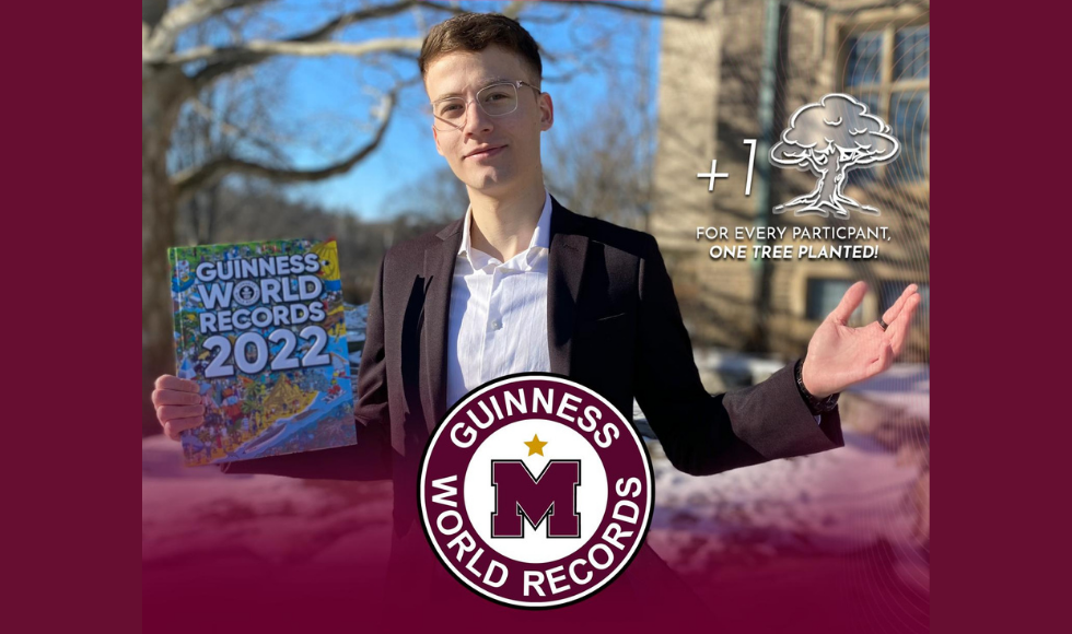 A graphic advertising MacWorldRecord's event. It shows a student holding A Guinness World Record book and looking directly at the camera.