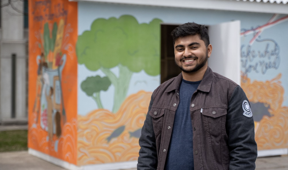 Sufal Deb standing in front of the McMaster Community Fridge