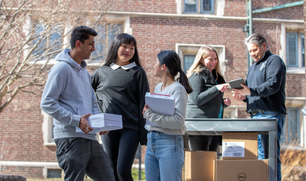 Three McMaster students and two staff members on McMaster's campus