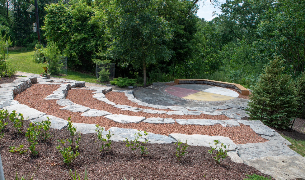 The Indigenous Circle at McMaster, a circular space divided into quarters, with curved tiers of stone stone seating radiating out from the centre.